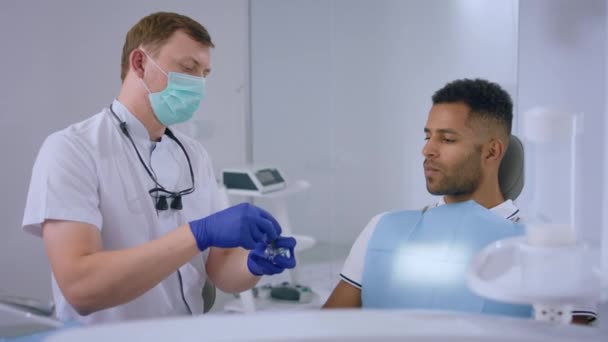 Стоматолога Добре Виглядає Пацієнт Який Сидить Стоматологічному Кафедрі Лікар Показує — стокове відео