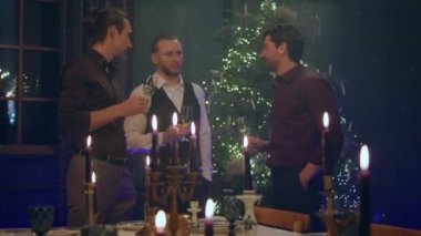 Noel atmosferini yemek odasındaki arkadaş grubunda Noel 'i ya da evde yeni yılı kutlayan erkek ve kadınlar harika dekorasyonlar yapıyorlar..