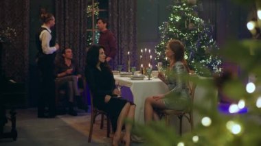 Harika bir yemek odasında Noel ya da yeni yıl kavramı. Harika dekorasyonlar yapan bir grup insan, yemek masasında iki muhteşem bayanı tartışırken diğer erkekler...