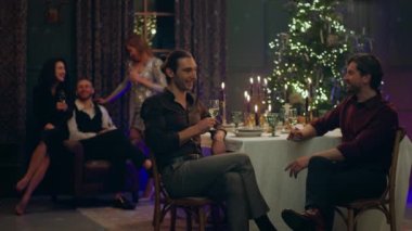 Çok yakışıklı ve yakışıklı iki adam Noel 'i birlikte kutlarken çok şehvetli bir şekilde tartışıyorlar. Yemek masasında oturuyorlar. Arkadaşları arka planda tartışıyorlar.