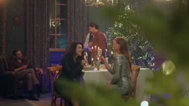 Noel 'in ya da Yeni Yıl' ın şaşırtıcı atmosferinde karizmatik kadınlar ve erkekler birlikte yemek masasında oturan bayanları kutluyor ve şampanya içiyorlardı.