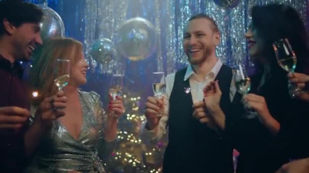 クラブでは 新年を祝う女性と男性が一緒にシャンパングラスを持ち 大きな笑顔で輝き 雰囲気を一緒に楽しんでいます — ストック動画
