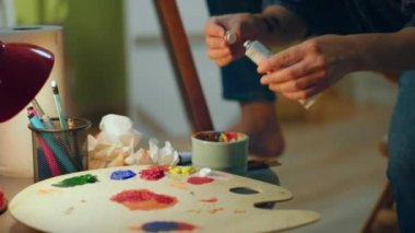 Tişörtünü paletine boya sürmüş güzel bir kadının yakın plan fotoğrafı ve resim stüdyosunda oldukça mutlu görünüyor. ARRI Alexa Mini 'de çekilen