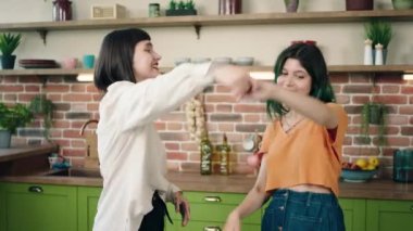 Excited lesbian couple in the morning dancing happy in the kitchen they hugging each other and feeling very excited concept of LGBT equality friendship. 4k