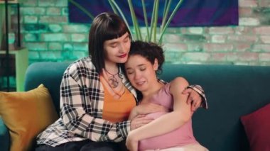In front of the camera happy lesbian couple waiting for a baby they enjoy the maternity at home they playing with the belly hugging and smiling large looking at each other with love. Shot on ARRI
