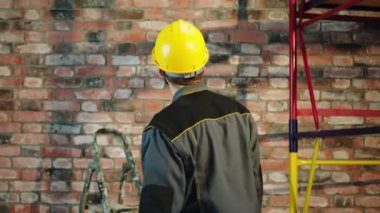 Modern building in construction builder man with safety equipment analysing and check the end of work then he turn to the camera posing and crossing hands looking straight. 4k