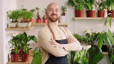 Great looking owner of the floral store posing in front of the camera he crossing hands and smiling large looking straight. 4k