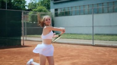 Good looking young woman professional tennis player hitting the ball hard outdoor on the tennis court she wearing uniform concept of healthy lifestyle and professional sport. Shot on ARRI