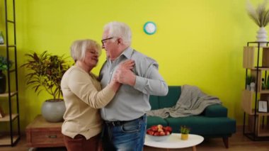 Happy and excited couple dancing together at home in living room they hugging each other and enjoy the time speeding together.