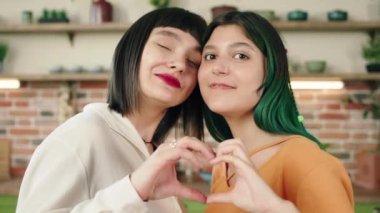 Kameraya gülümseyen güzel lezbiyen çift LGBT özgürlük kavramından büyük bir kalp yapıyorlar. ARRI Alexa Mini 'de çekilen