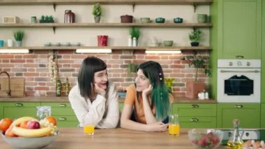Kameranın önünde, LGBT arkadaşlık eşitliği özgürlüğü konseptini hazırlamak için mutfak adasında kalmadan önce birbirlerine bakan harika lezbiyen kadınlar. 4k