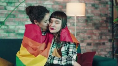 Good looking lesbian couple very Attra multiethnic spending time together hugging with love each other they holding the LGBT a rainbow flag. 4k
