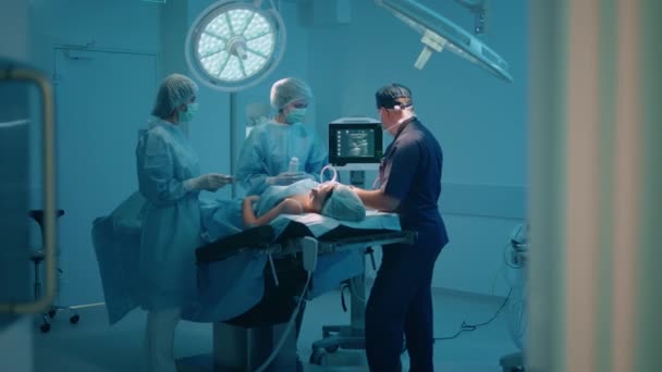 Zwei Frauen Und Ein Männlicher Chirurg Stehen Einem Blau Getönten — Stockvideo