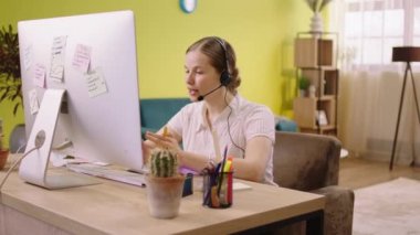 Discussing from computer on video call charismatic woman customer support service she explains something to the client at home she wear the headset. 4k