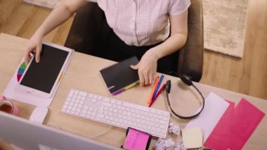 Taking video from the top the office worker woman make some organiser at her work place on the office table. 4k