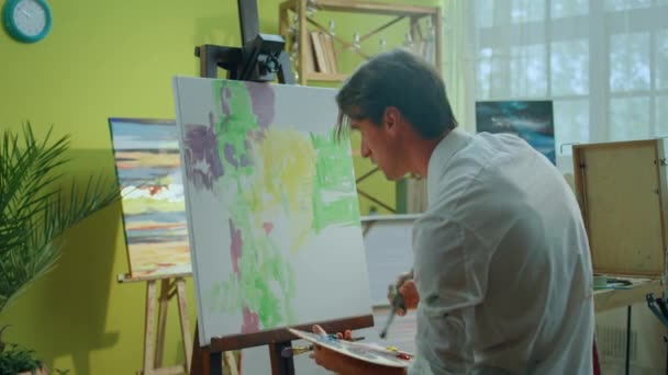 Przystojny Przystojny Artysta Swoim Studio Maluje Nowy Obraz Płótnie Dodaje — Wideo stockowe