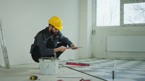 Seorang Tukang Bangunan Lokasi Konstruksi Memperbaiki Ubin Lantai Bangunan Industri — Stok Video