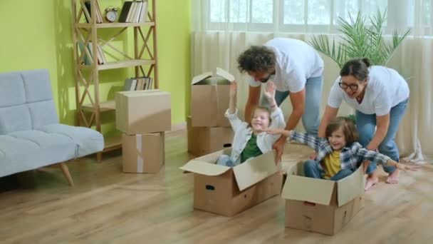 Nowym Domu Szczęśliwi Podekscytowani Rodzice Biorą Dwójkę Swoich Małych Dzieci — Wideo stockowe