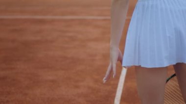 Açık hava tenis kortunda kameranın önünde profesyonel tenisçi kadının tenis topuna raketle sert vurduğu kameraya yakın çekim. ARRI Alexa Mini 'de çekilen