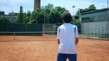 Genç adam tenis kortunda antrenman yapıyor profesyonel topa vuruyor sağlıklı raket konseptiyle..