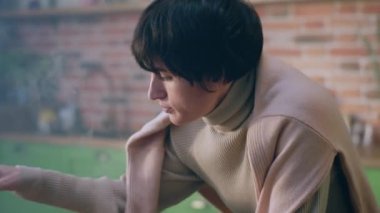 Mutfak adasındaki kameraya yakın. Kısa saçlı kadın haplarına bakıyor ve onları analiz ediyor. Kendini hasta hissediyor..