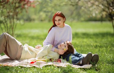 Parkın ortasında çok güzel lezbiyen kadınlar kameranın önünde poz veriyor ellerinde Igbt bayrağı ve gülümsüyorlar..