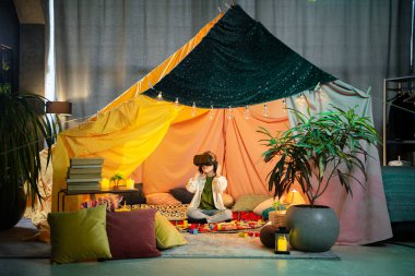 Çok iyi geçinen küçük çocuk kendi büyük renkli battaniye çadırlarında sanal gerçeklik kulaklıklarıyla oynuyorlar..