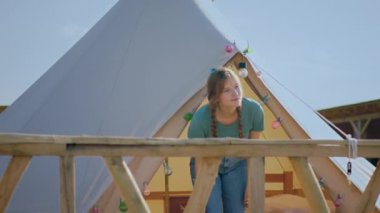 Uzun saçlı güzel bir bayan geldi ve gülümsüyordu. Etrafa bakıyordu. Kamp alanının ortasındaki yeri keşfediyordu..