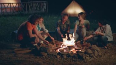 Çok ırklı bir grup arkadaş için çok özel anlar. Kamp alanındaki samanlıkta otururken yangın kazığında sosis pişiriyorlar. ARRI 'de çekilen