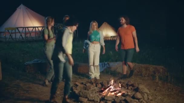 火の杭踊りと歌の横のキャンプ場での友人の女性と男のグループは すべて一緒に夜の時間で瞬間をお楽しみください Arriで撃たれた — ストック動画