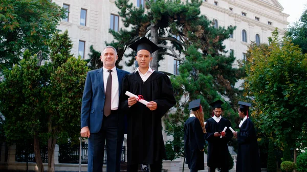 カリスマ的な男大学校長と一緒にカメラの前で卒業証書ポーズで興奮した大学院生 Arri Alexa Mini — ストック写真