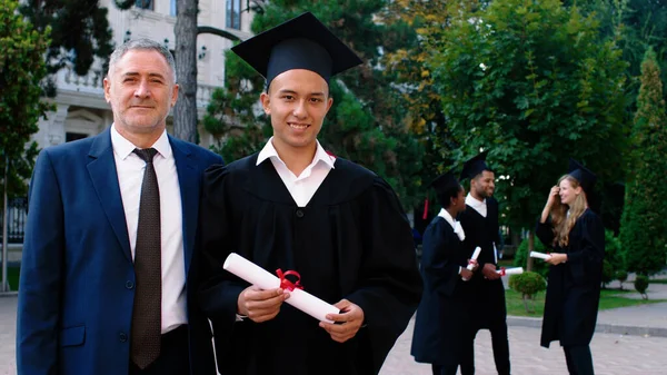 カリスマ的な男大学校長と一緒にカメラの前で卒業証書ポーズで興奮した大学院生 Arri Alexa Mini — ストック写真