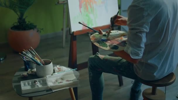 芸術教育の概念創造性の芸術家の男彼のアートスタジオで手にパレットを保持しながら 彼は油の色を使用してキャンバス上の新しい絵画を作成します — ストック動画