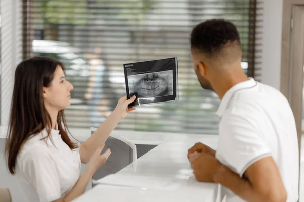 在一个现代化的大型诊所里 病人从接待处用X光检查结果 然后去看医生 — 图库照片