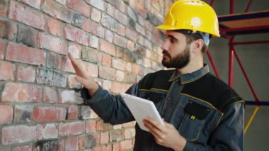 Foreman 'ın ekibinin çalışmalarını analiz ederken ki videosunu çekerken kameraya yakından duvara dokunuyor ve not defterine güvenlik kaskı ve ekipmanı taktığını not alıyor. 4k