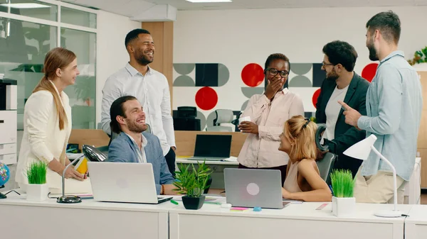 オフィスセンターの非常にカリスマ的な黒の女性のオフィスマネージャーや他の同僚は いくつかのコーヒーの女性を飲みながら会議を持っている面白い話をすべてのオフィスの労働者は大笑いし 持っている — ストック写真