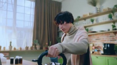 Harika görünümlü dişi çaydanlığı al ve mutfak adasında dururken çay bardağına biraz sıcak su ekle. 4k