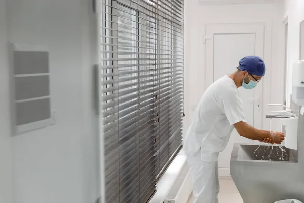 在现代化医院手术室的手术室里 在开刀前 外科医生们把手洗得很好 并戴上了医用制服和防护面罩 — 图库照片