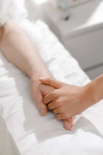 Pacjent Leżący Szpitalnym Łóżku Młody Człowiek Trzymający Rękę Zachęcający Pacjenta — Zdjęcie stockowe