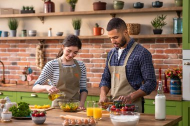 Yakışıklı bir adam ve karısı sabah mutfağında taze portakal suyu içerek birlikte bakıyorlar..