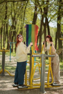 Parkta iki karizmatik bayan dışarıda spor yapıyor ve biraz temiz hava alıyor. Birlikte vakit geçiriyorlar..