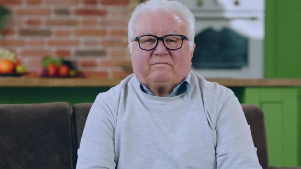 Kameranın Önünde Yaşlı Adam Yemek Odasındaki Kanepede Otururken Doğrudan Kameraya — Stok video