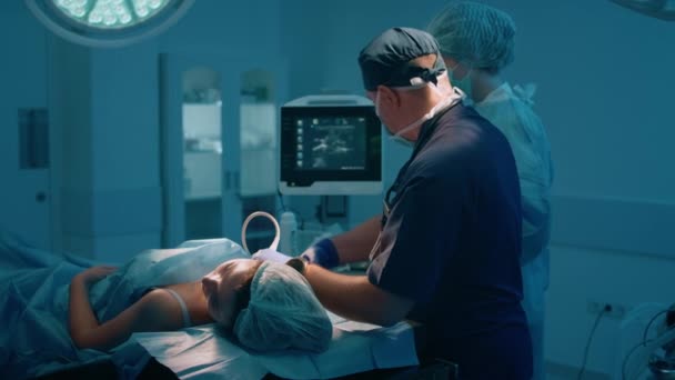 外科医は患者のバイタルを服用し 手術前にすべてが健全であることを確認し すべてのバイタルがコンピュータ画面に表示され 集中しています 4Kについて — ストック動画