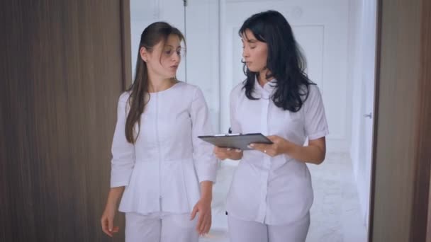 Amazing Looking Two Nurses Medical Clinic Meeting Corridor Discussing Program — Vídeo de Stock