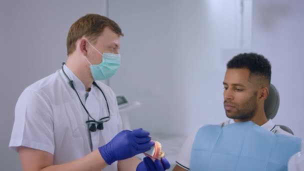 Modern Large Dental Clinic Dentist Using Tooth Model Explain Patient — стокове відео
