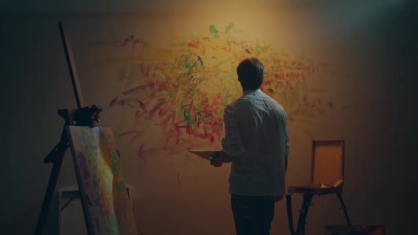 现代画家男人在他的艺术工作室的墙上用油彩和手指来画这幅画 — 图库视频影像