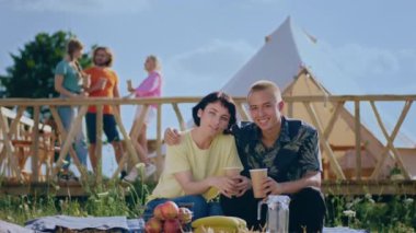 Kameranın önünde poz veren güzel çift, kamp alanının ortasında birlikte anın tadını çıkarıyorlar. Düz baktıkları için heyecanlılar. 4k