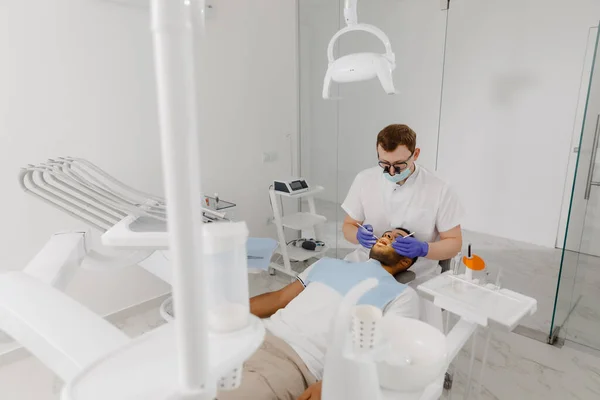 现代牙科诊所牙医用牙科器械对病人进行牙齿治疗 病人躺在牙医椅子上的保健理念 — 图库照片
