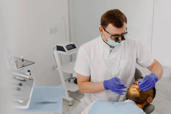 在现代牙科诊所 病人有一个牙齿预约 他非常仔细地检查牙医的健康状况 — 图库照片