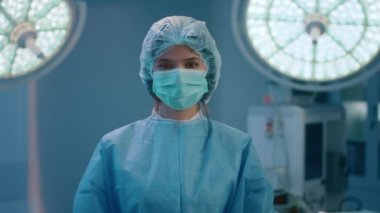 Güzel bir hemşire, pozitif bir atmosferde çok parlak bir ışıkla cerrahi bir odada duruyor.